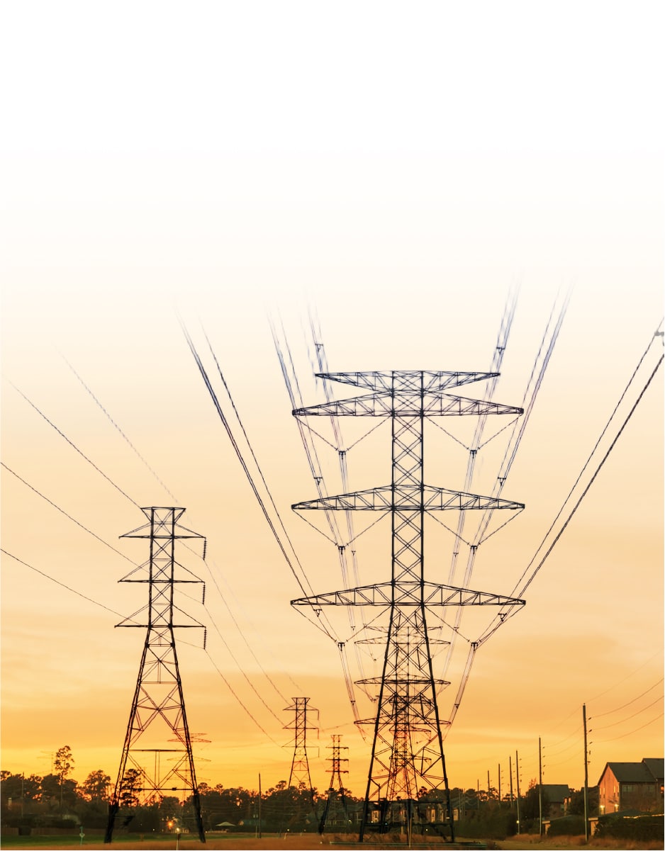 Power transmission lines stretch across the horizon at sunset, carrying electricity from renewable energy sources to homes and businesses.